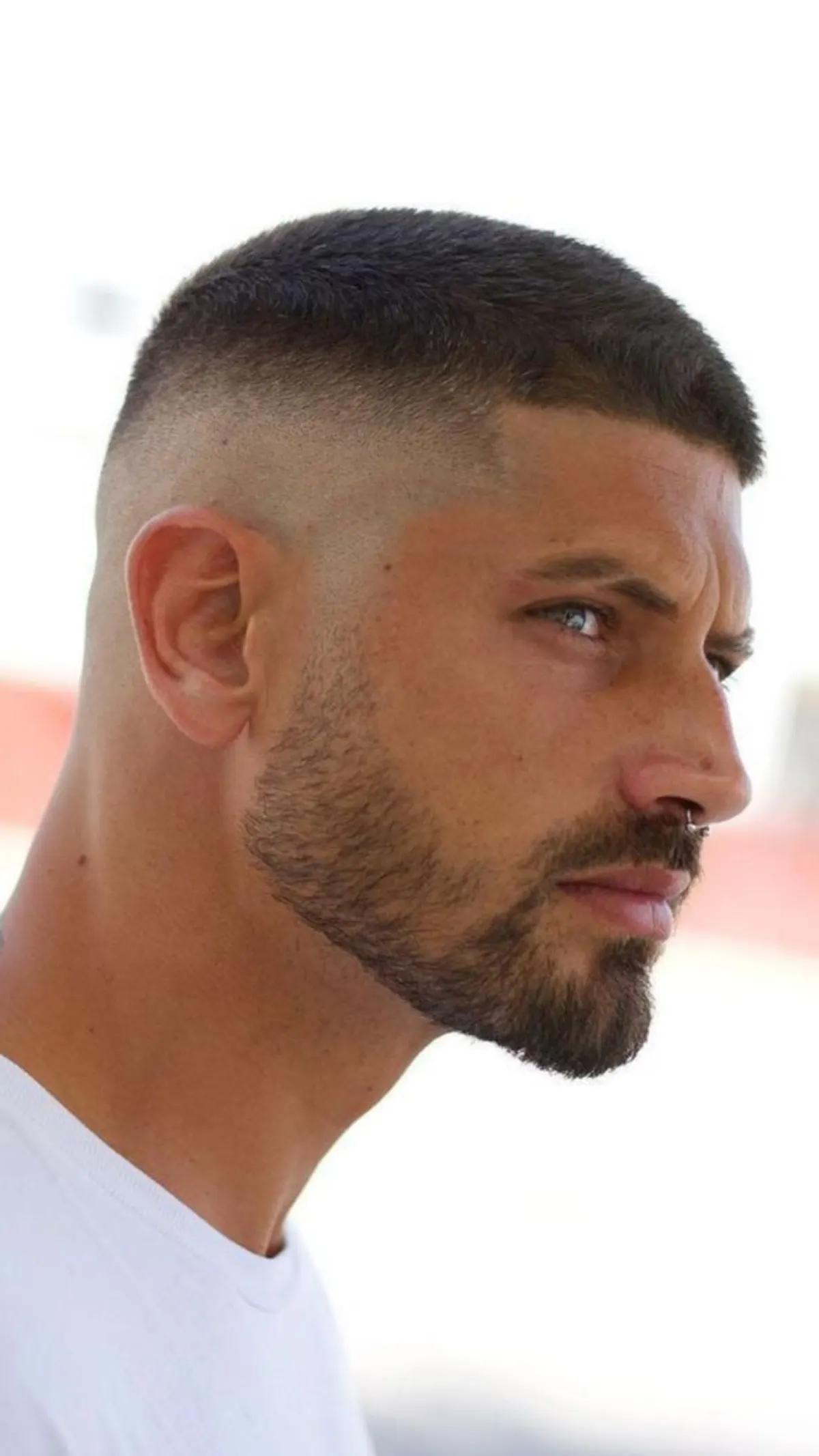 Corte rapado tipo buzz cut con degradado alto y barba