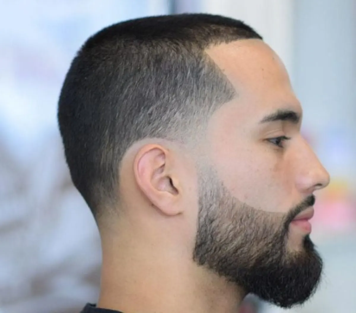 Degradado corto con barba difuminada y perfilado frontal marcado